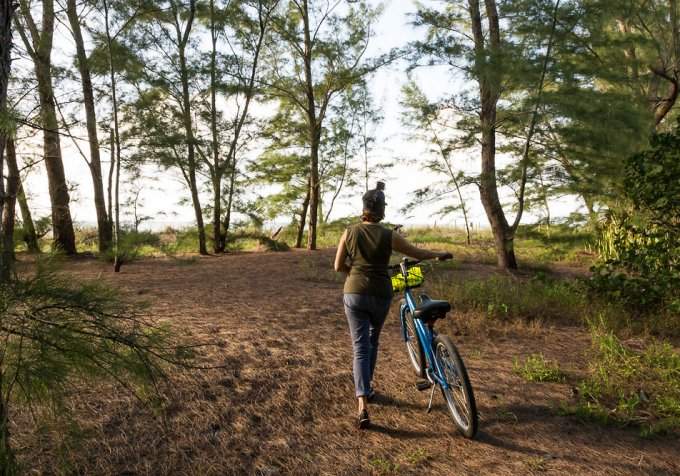 women with bike walking down dirt road