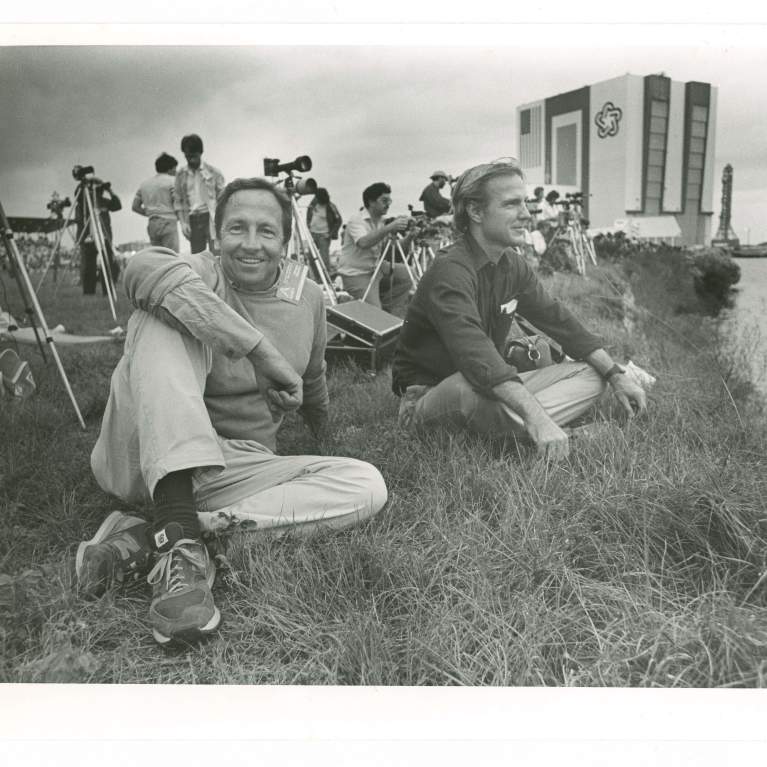 two men sitting in grass