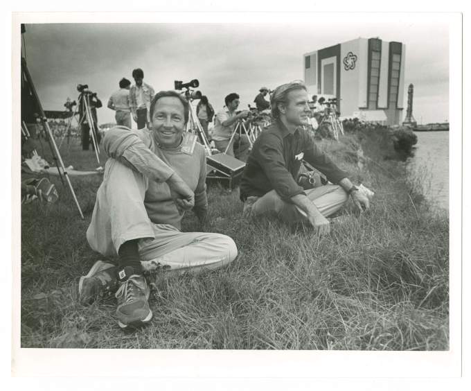 two men sitting in grass