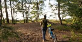 women with bike walking down dirt road